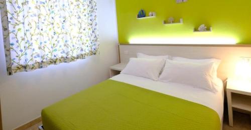 マッティナータにあるARBI case vacanzeの緑と白のベッドルーム(ベッド1台、デスク付)