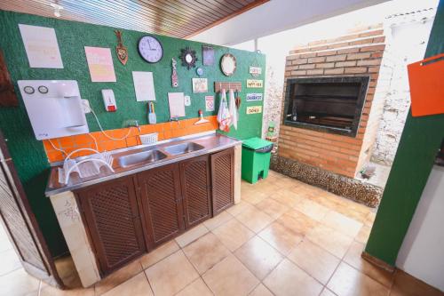 a kitchen with a sink and a brick fireplace at Hotel Hostel Caçari in Boa Vista
