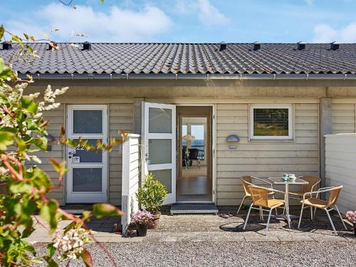 una pequeña casa con una mesa y sillas frente a ella en 4 person holiday home in Allinge, en Allinge