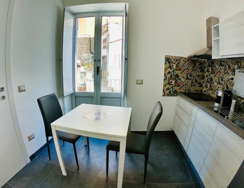 a small kitchen with a white table and chairs at "Sweet Life" Casa Vacanze in Lipari