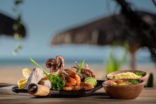 a plate of food with seafood on a table at Pousada Mi Secreto in São Miguel do Gostoso