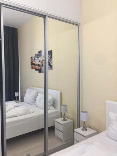 a mirror in a bedroom with two beds and two lamps at Dune B Apartment in Mielno