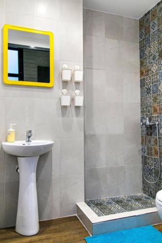a bathroom with a sink and a mirror and a shower at Iconic Athens Hostel in Athens