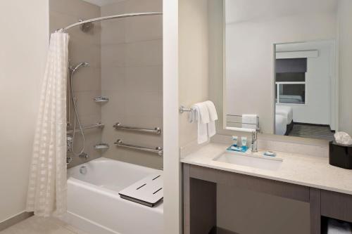 uma casa de banho com uma banheira, um lavatório e um chuveiro em Hyatt House Irvine/John Wayne Airport em Irvine