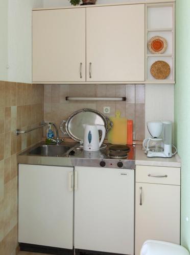 a kitchen with white cabinets and a sink at Apartments Milana in Tučepi
