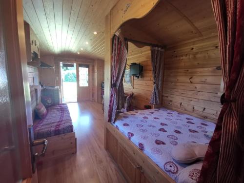 een slaapkamer met een bed in een blokhut bij Roulotte du Soleil in Eyragues