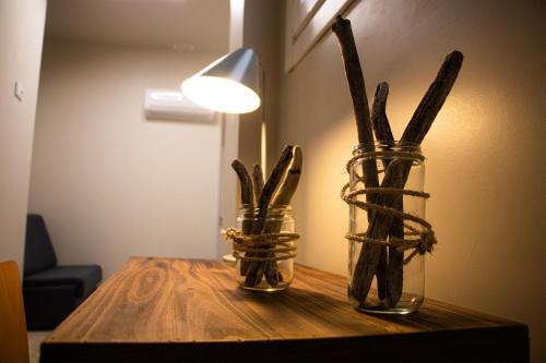 two glass vases with sticks in them on a table at Acolá Rooms in Pontevedra