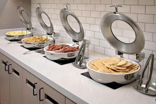 a kitchen counter with bowls of food and mirrors at Hyatt House Irvine/John Wayne Airport in Irvine