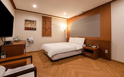 Dormitorio con cama, escritorio y TV en Incheon Airtel en Incheon