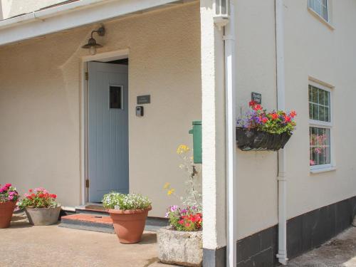 a house with flower pots on the side of it at Little Piccadilly in Totnes
