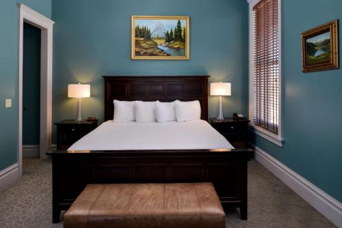 1 dormitorio con 1 cama grande y paredes azules en Montvale Hotel en Spokane