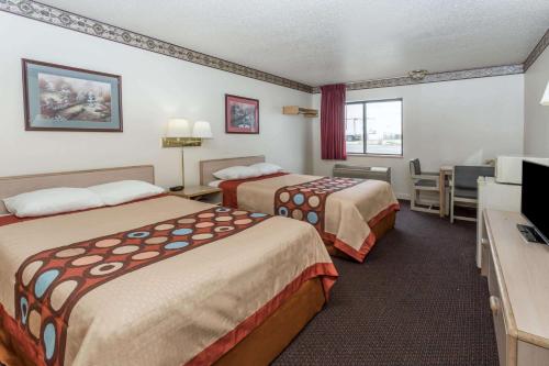 a hotel room with two beds and a television at Super 8 by Wyndham Morris in Morris