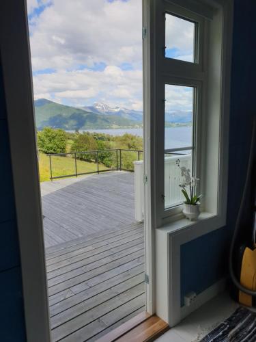 a door to a balcony with a view of the water at Irenegarden - Fjord view holiday home in Lauvstad