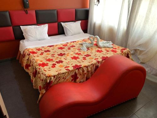 ein Bett mit einem roten Stuhl neben einer roten Couch in der Unterkunft Manantail Hotel No.003 in Puente Piedra