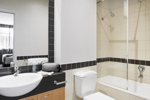 a bathroom with a toilet and a sink and a shower at Punthill Apartment Hotel - Flinders Lane in Melbourne