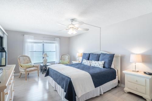 a bedroom with a bed and a ceiling fan at Reflections Gulf Front Condo With Ocean Views in Clearwater Beach