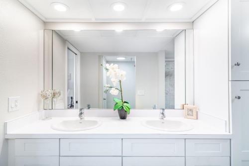 a bathroom with two sinks and a large mirror at Reflections Gulf Front Condo With Ocean Views in Clearwater Beach