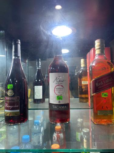 a group of bottles of alcohol on a shelf at Manantail Hotel No.003 in Puente Piedra