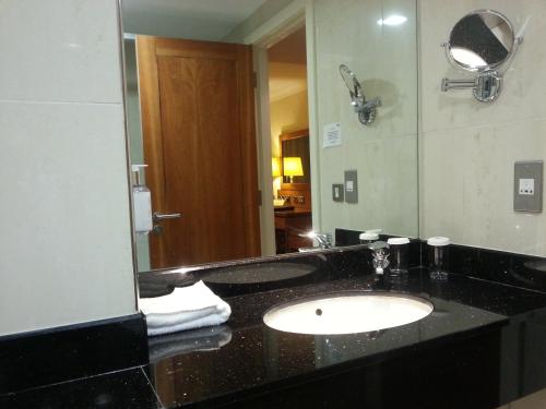 y baño con lavabo y espejo. en Tara Hotel en Killybegs