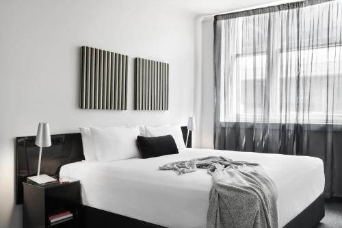 a hotel room with a bed and a lamp at Punthill Apartment Hotel - Flinders Lane in Melbourne