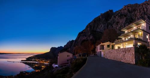 a building on the side of a mountain at dusk at Villa The View in Omiš