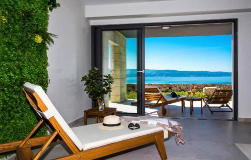 a room with a patio with a view of the ocean at Villa The View in Omiš