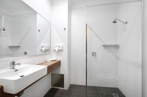 a bathroom with a sink and a shower at New England Motor Inn in Armidale