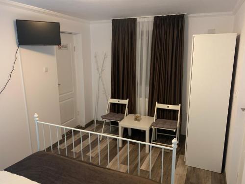 - une chambre avec deux chaises, un lit et une fenêtre dans l'établissement Casa De Sub Munte, à Buşteni