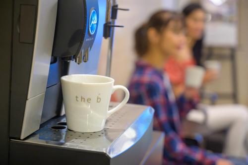 a coffee cup sitting on top of a computer monitor at the b hakata in Fukuoka