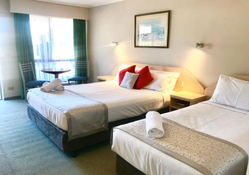 a hotel room with two beds and a table at Burwood East Motel in Burwood