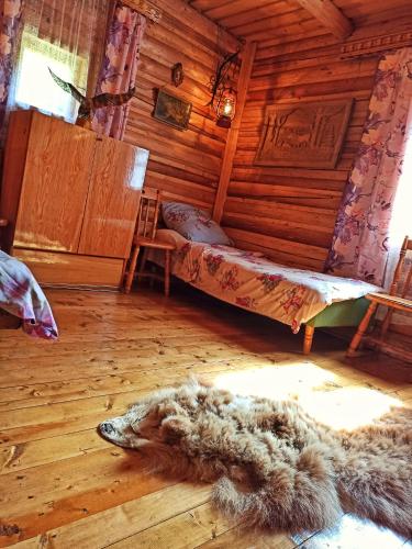 a room with a bed and a rug on the floor at Еко Садиба Під Полониною in Sasivka