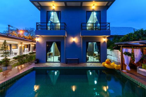a house with a swimming pool in front of a house at Aownoi Bay Resort in Prachuap Khiri Khan