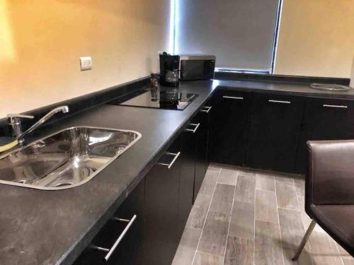 a kitchen with a sink and a microwave at 8 Loft for two people in Torreón