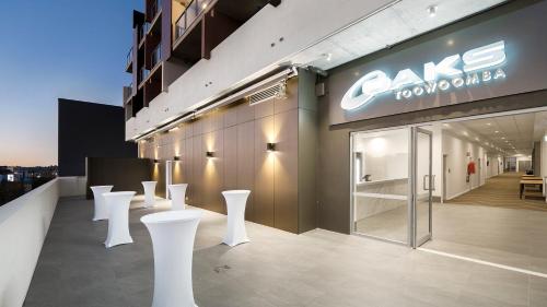 a store with white stools in front of a building at Oaks Toowoomba Hotel in Toowoomba