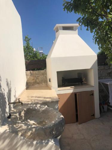 a white building with a sink in a yard at Spiti Calliope in Kathikas