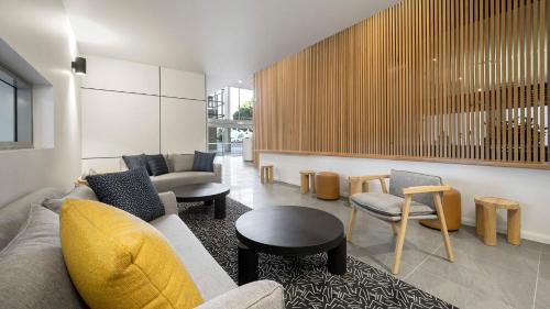 a living room with a couch and a table and chairs at Oaks Toowoomba Hotel in Toowoomba