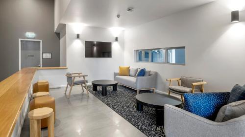 a living room with couches and chairs and tables at Oaks Toowoomba Hotel in Toowoomba