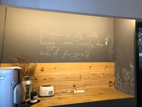 a wall with a sign that reads expect your day well havingoften secretlysiesie at Shane Hotel in Chiang Mai