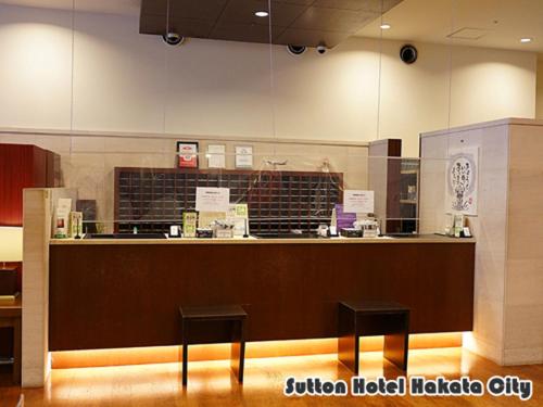 福岡的住宿－博多市善騰酒店，一个带两个黑凳子的柜台的餐厅