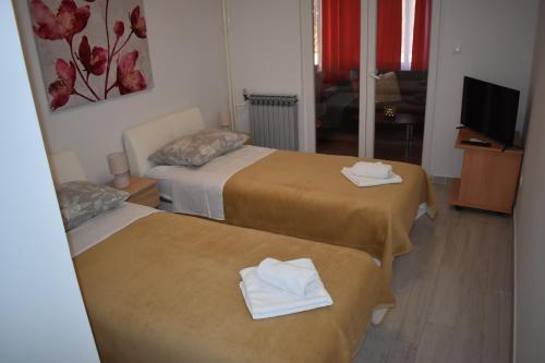 a hotel room with two beds with towels on them at Korcula Apartments Iliskovic in Korčula