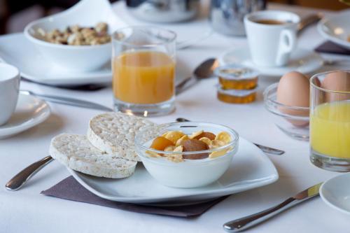 a table with a plate of breakfast foods and drinks at Park Hotel in Mondovì