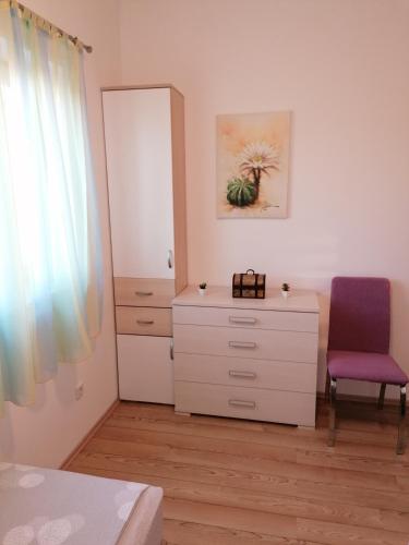 a bedroom with a dresser and a chair and a mirror at Apartman Šuperba A1 in Šibenik