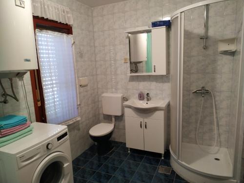 a bathroom with a toilet and a sink and a shower at Holiday Home Latin in Peruški