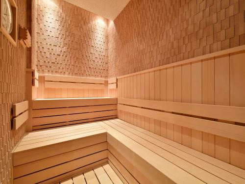 an empty sauna with wooden panels and brick walls at Hotel Elcient Osaka in Osaka