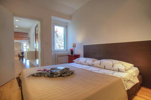 sypialnia z dużym łóżkiem z drewnianym zagłówkiem w obiekcie Casa Marina Apartments w Szybeniku