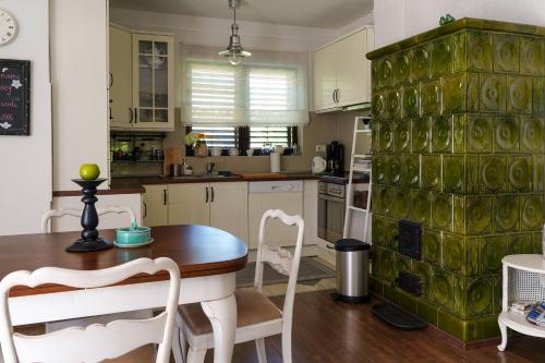 a kitchen with a table and a green wall at Wéber Villa in Gyenesdiás