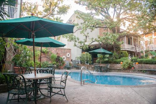 a table and chairs with an umbrella next to a pool at Place D'Armes Hotel in New Orleans