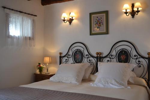 a bedroom with a white bed with two pillows at Casa Rural Claudio in Villa de Mazo