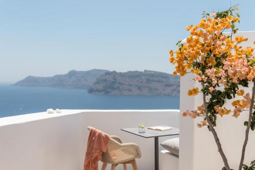 a room with a table and flowers on a white wall at Aspaki by Art Maisons in Oia