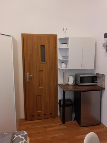 a kitchen with a door and a table with a microwave at pokoj z lazienka Sopot in Sopot